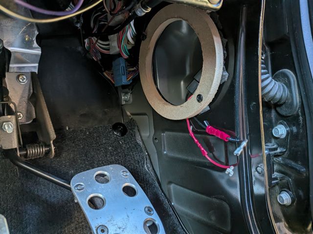 MDF spacer ring test-fitted in the driver-side kick panel
